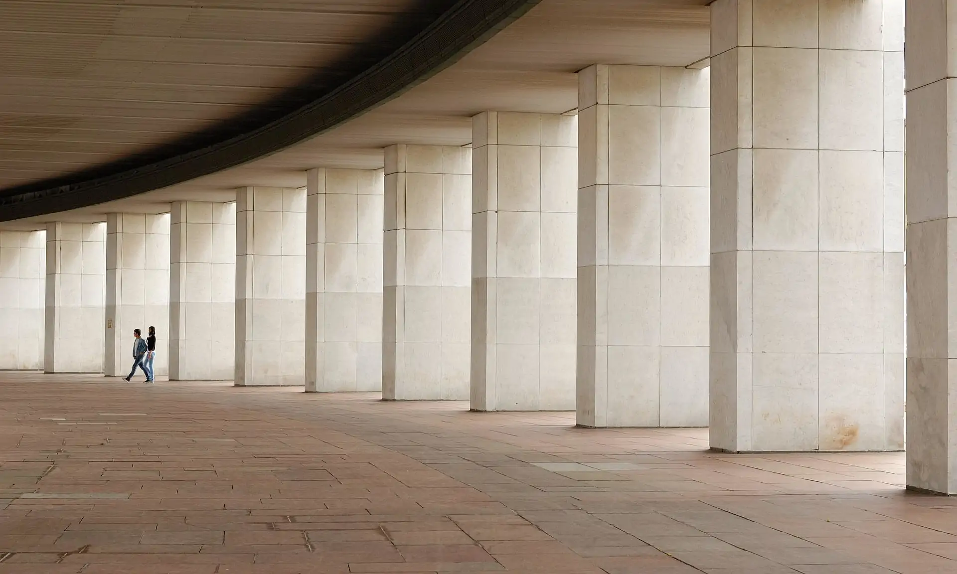 Two people walking along a passageway